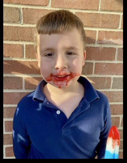 Boy with popsicle on his face